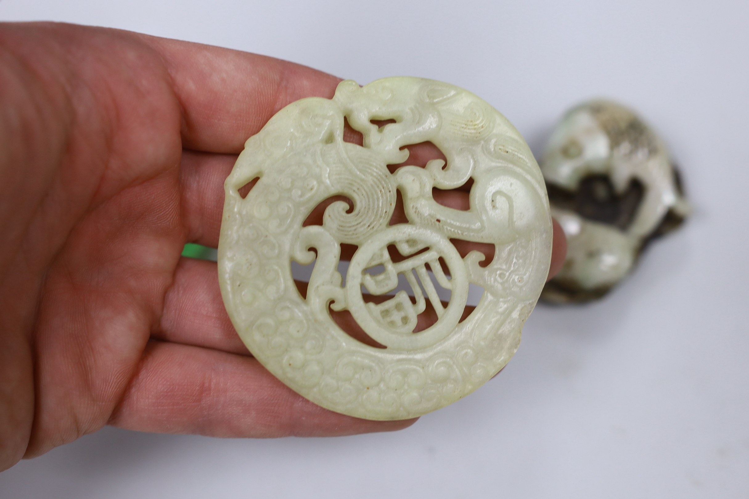 A Chinese hardstone carved roundel, a ring and a fish panel, roundabout 7cm diameter